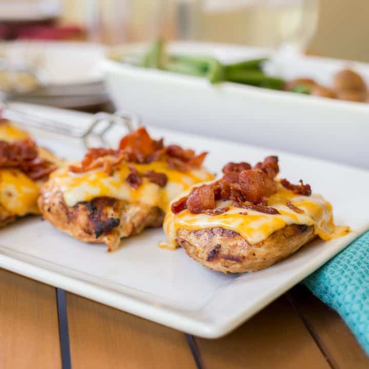Monterey Chicken with cheese and bacon on an outdoor serving dish.