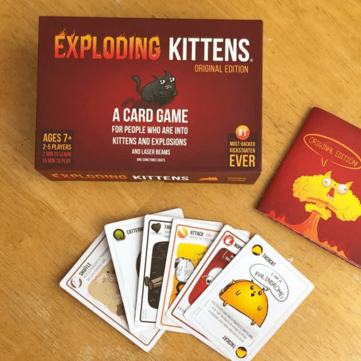 The card game Exploding Kittens Game layed out on a table with the cards displayed.