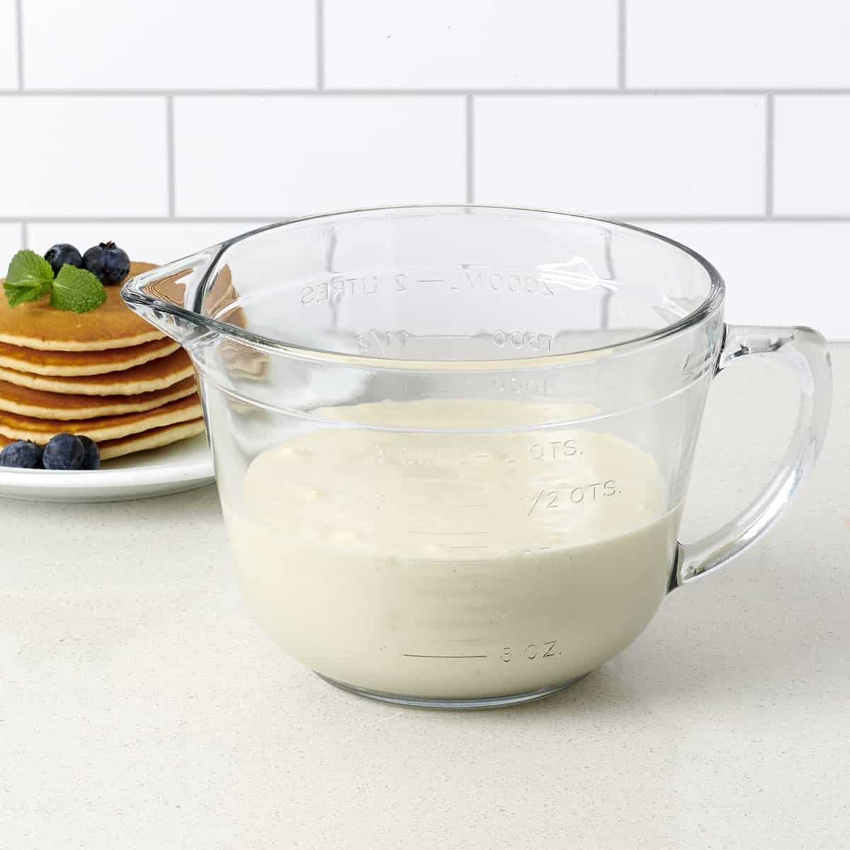 Glass food storage container filled with pancake batter that serves as a mixing bowl and measuring cup too!