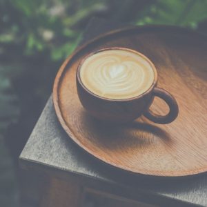 Cup of coffee on a wood tray.