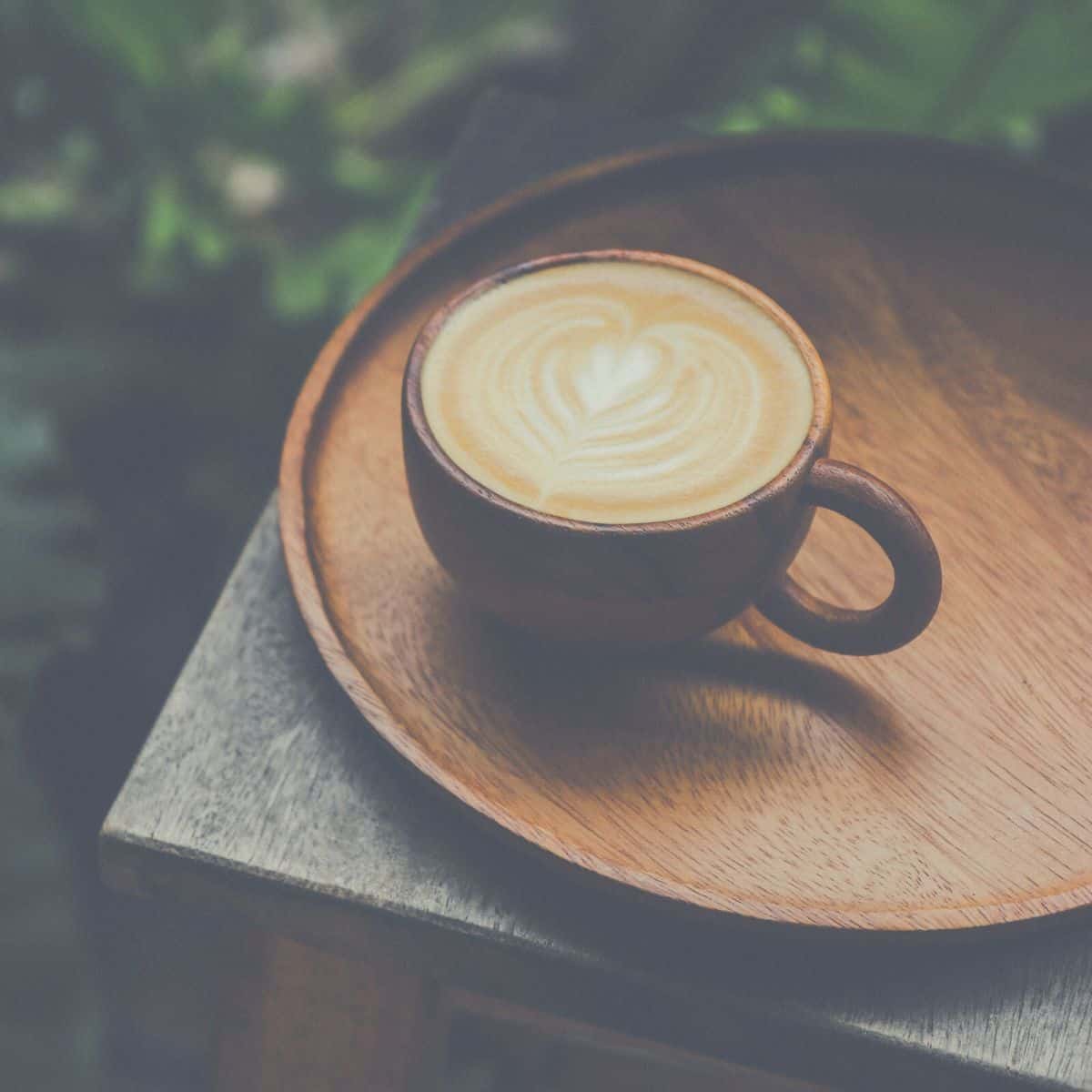 A cup of coffee on a wooden tray.